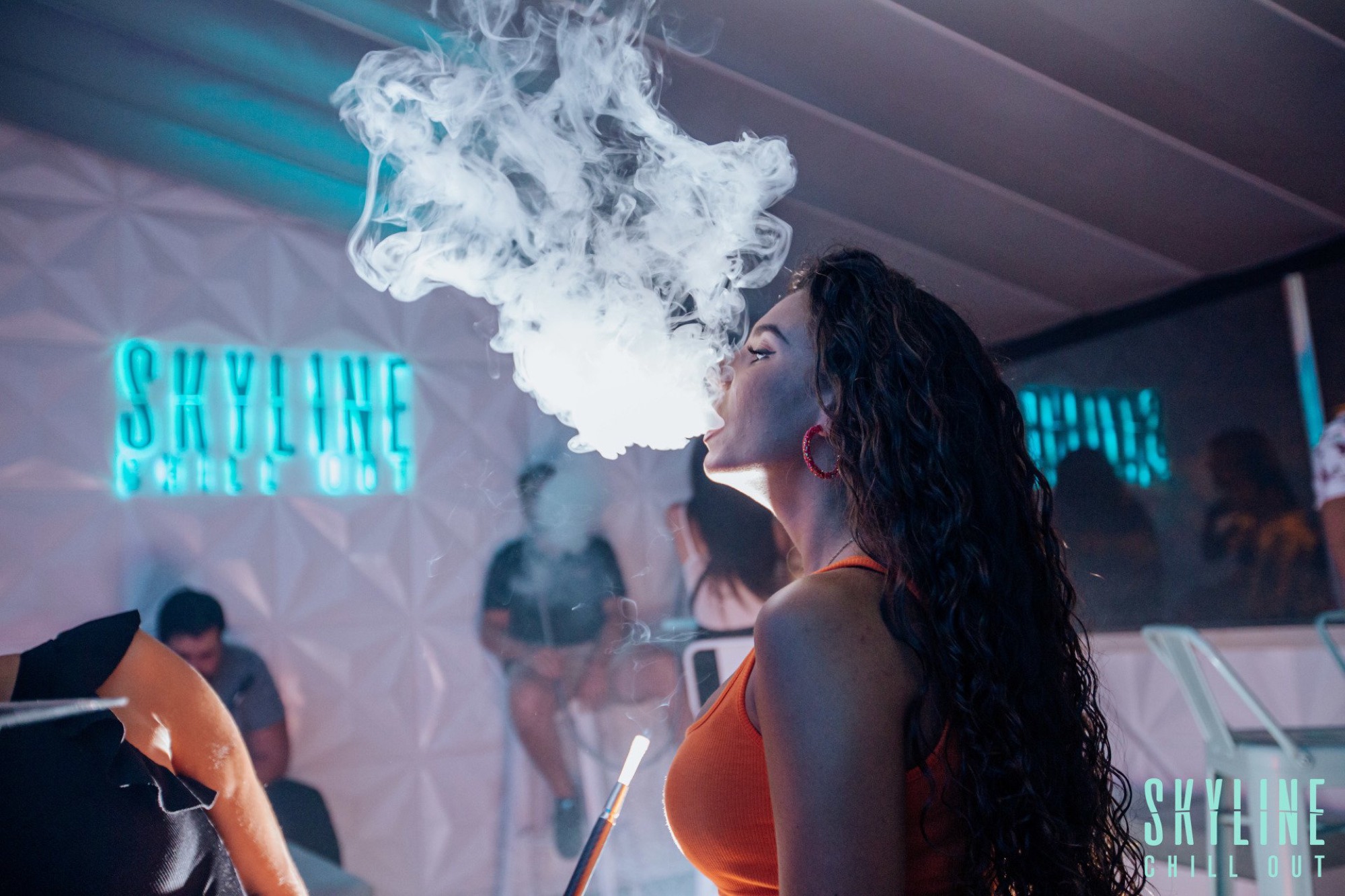 Nube de shisha bajo el neón de Skyline
